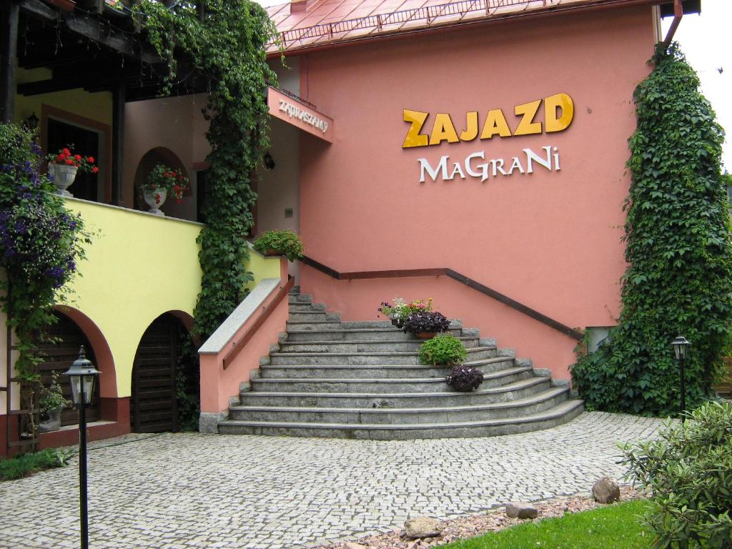 un edificio con escaleras y un cartel en él en Zajazd Magrani, en Lubawka