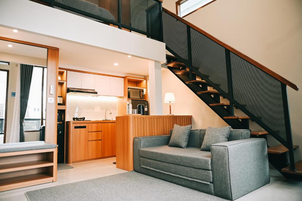 un salon avec un canapé et un escalier dans l'établissement Djayati Loft Stay, à Timuran