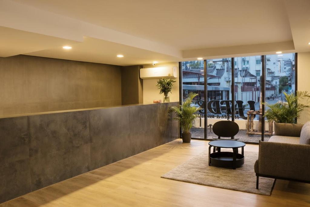 A reception lobby with a long desk, lounge seating and a street-facing glass frontage.