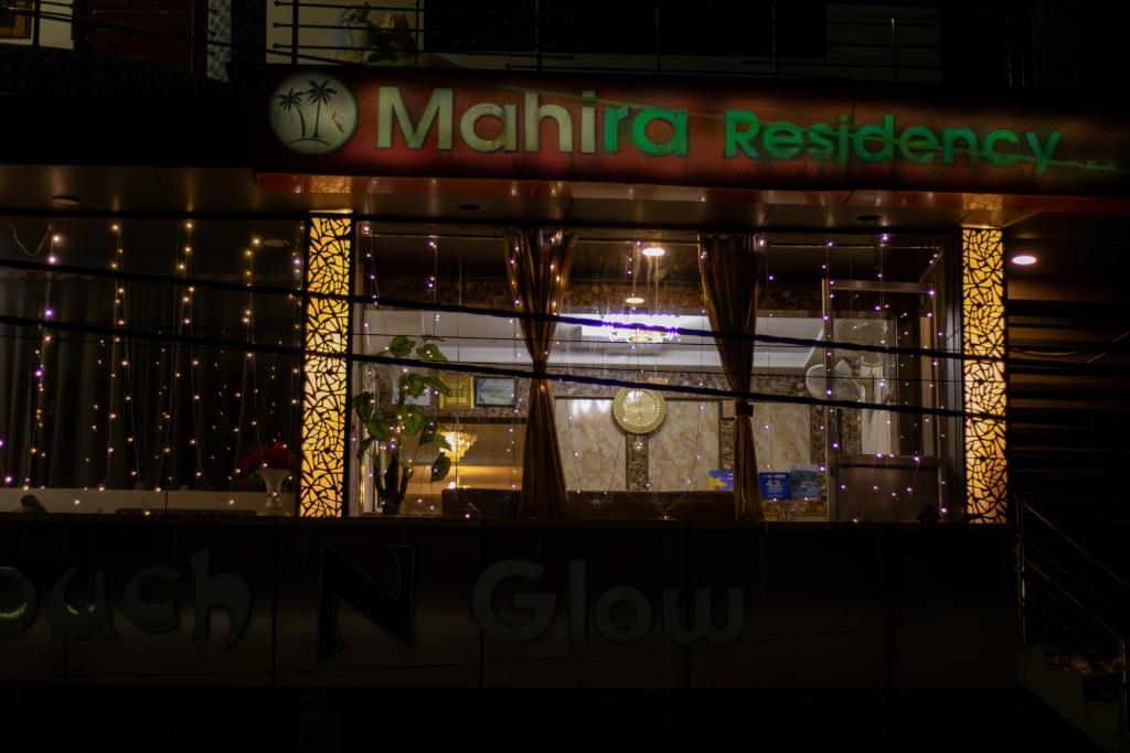 ein Fenster eines Restaurants bei Nacht mit Lichtern in der Unterkunft MAHIRA RESIDENCY in Port Blair