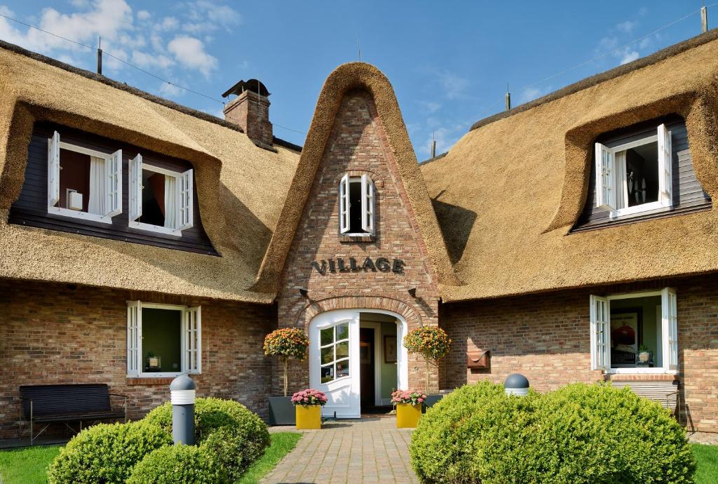 a building with a thatched roof at Hotel Village in Kampen