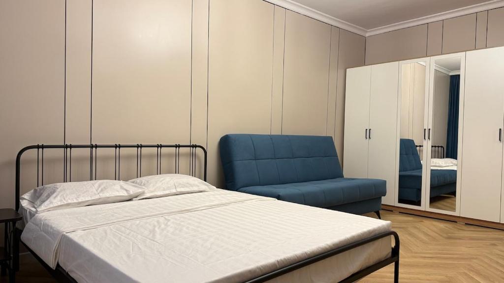 a bedroom with a bed and a blue chair at Kurmangazy in Zhezdi