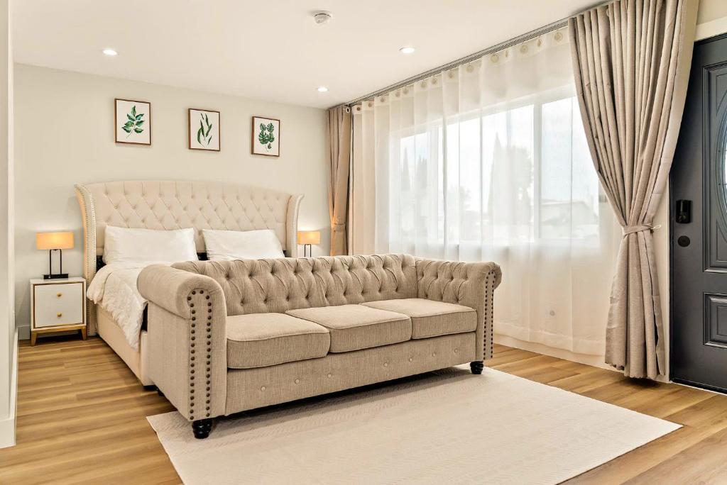 a bedroom with a couch and a bed and a window at Lyn's Stay in Westminster