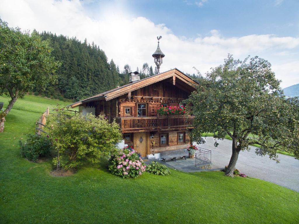 a wooden house with a balcony on a river at Alpen-Chalet-Pankraz in Fügenberg