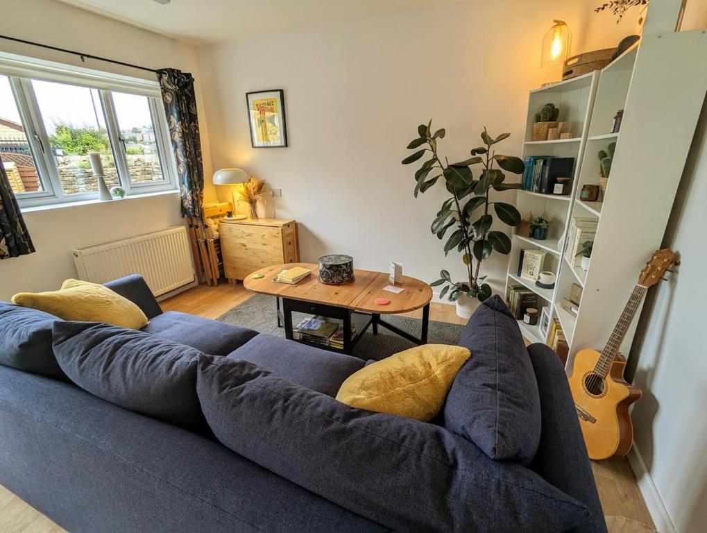 een woonkamer met een blauwe bank en een tafel bij Loxley View Guest House in Hillsborough