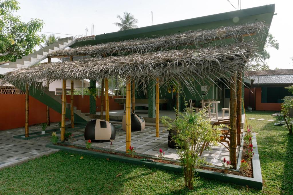 a house with a thatched roof in a yard at Social Stays in Negombo