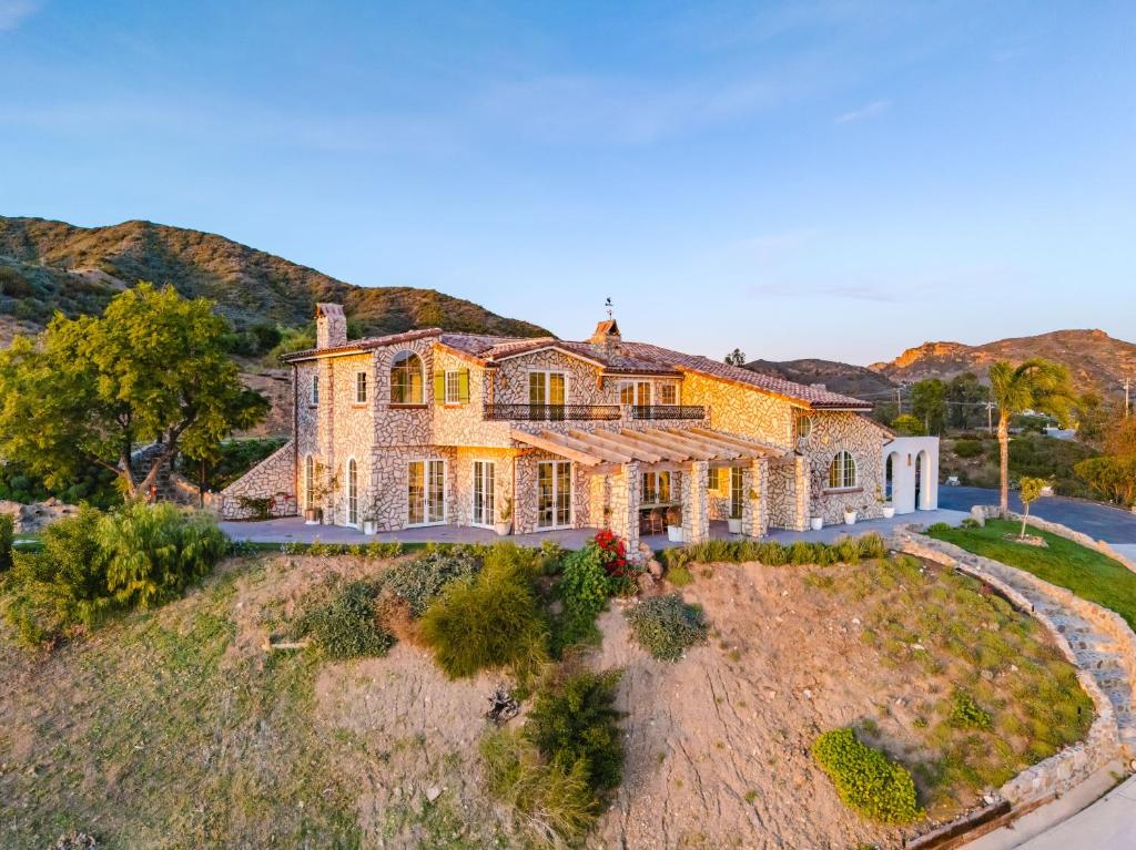 an exterior view of a large house with mountains in the background at Mintcello Estate in Malibu