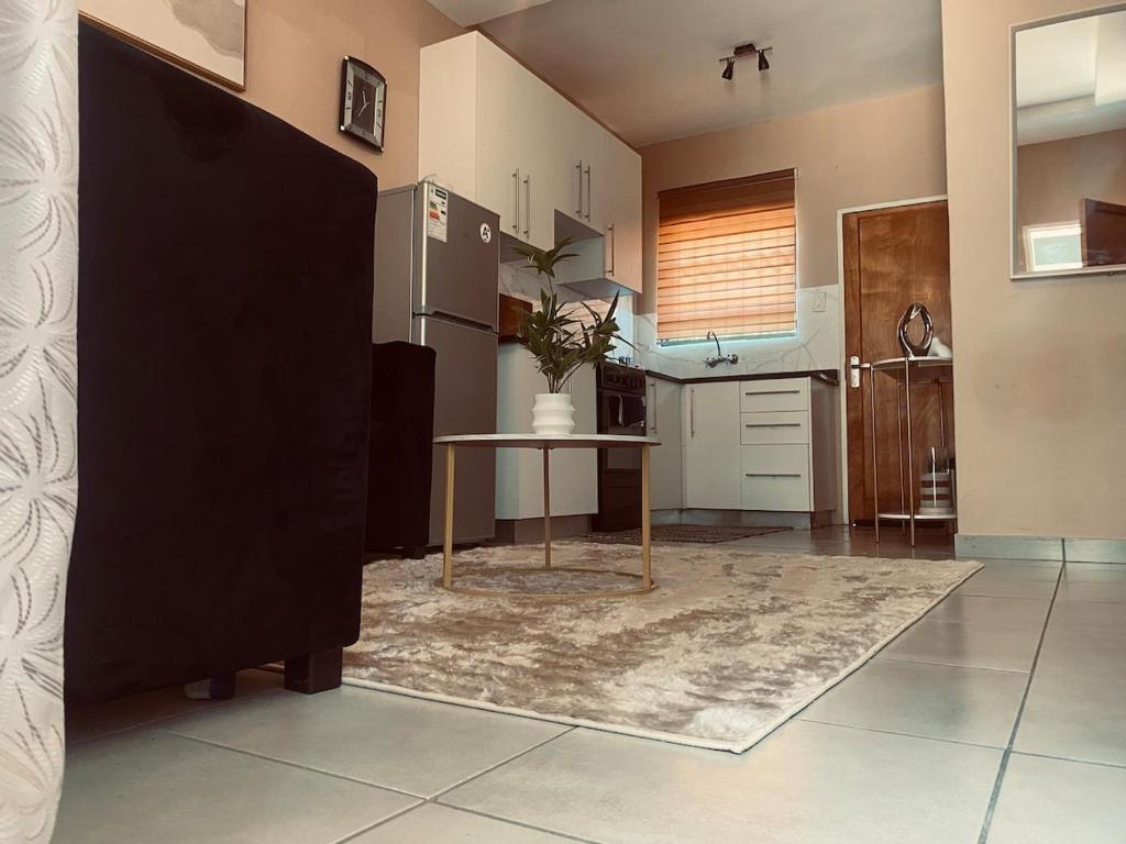 une cuisine avec une table et un réfrigérateur dans l'établissement Cozy Haven in Manzini, à Manzini