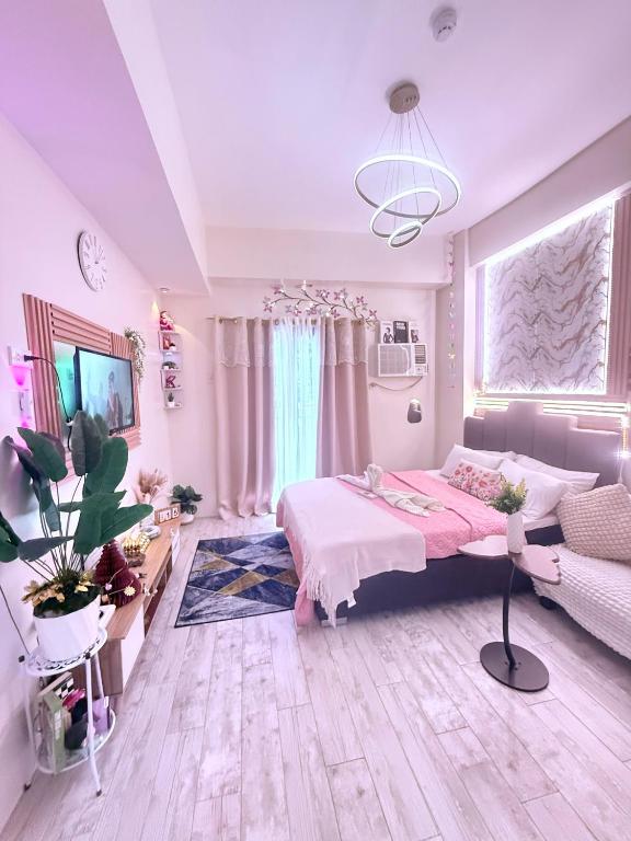 a bedroom with a bed and a large window at Fyangz Mini Karaoke Condo Staycation in Minglanilla
