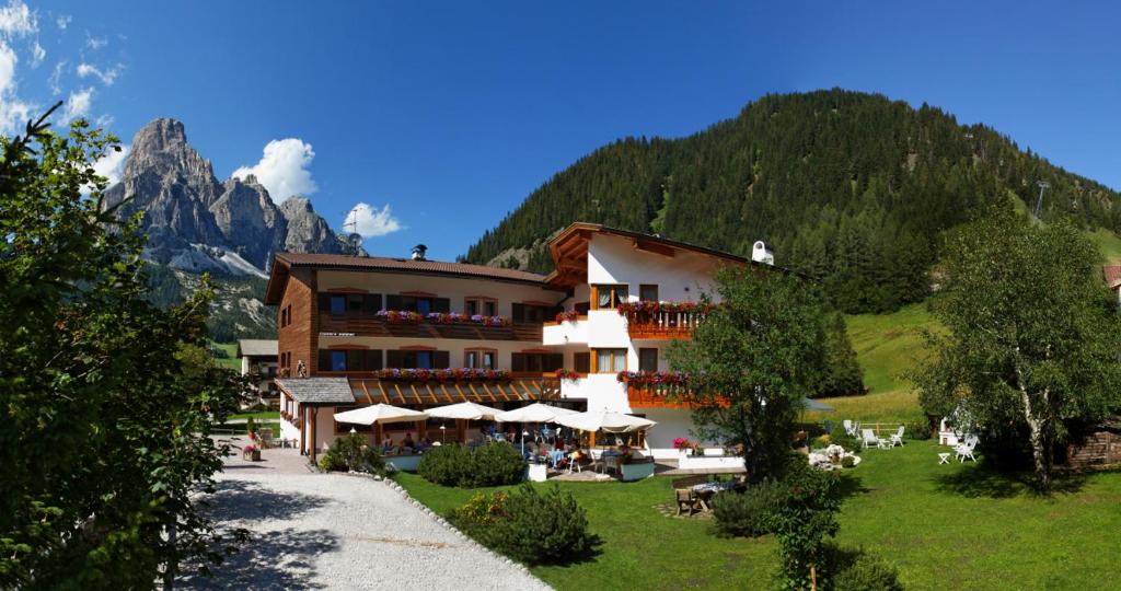 un hotel en las montañas con una montaña en Garni Raetia en Corvara in Badia