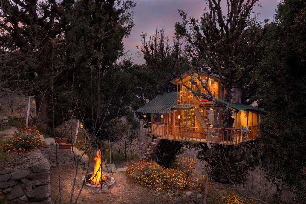 uma casa na árvore com uma lareira em frente em Rumsu Tree House by SLC em Nagar