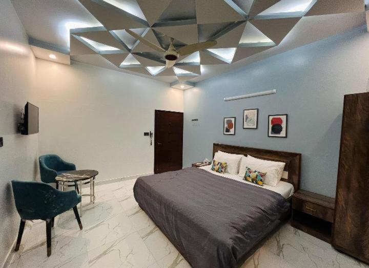 a bedroom with a bed and a ceiling fan at Karachi inn Guest in Dargai