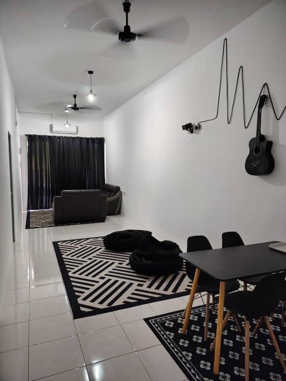 a living room with a table and chairs and a couch at Nazana Homestay in Batu Gajah