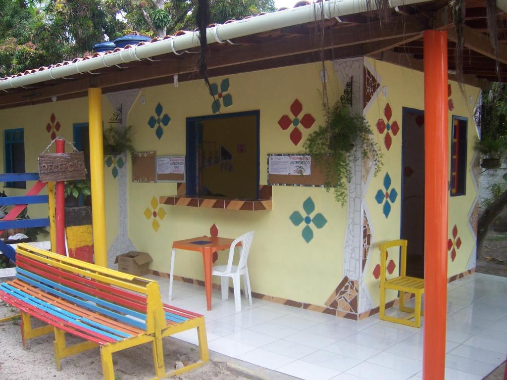 una pequeña casa con mesa y sillas al aire libre en Albergue da Gamboa, en Morro de São Paulo