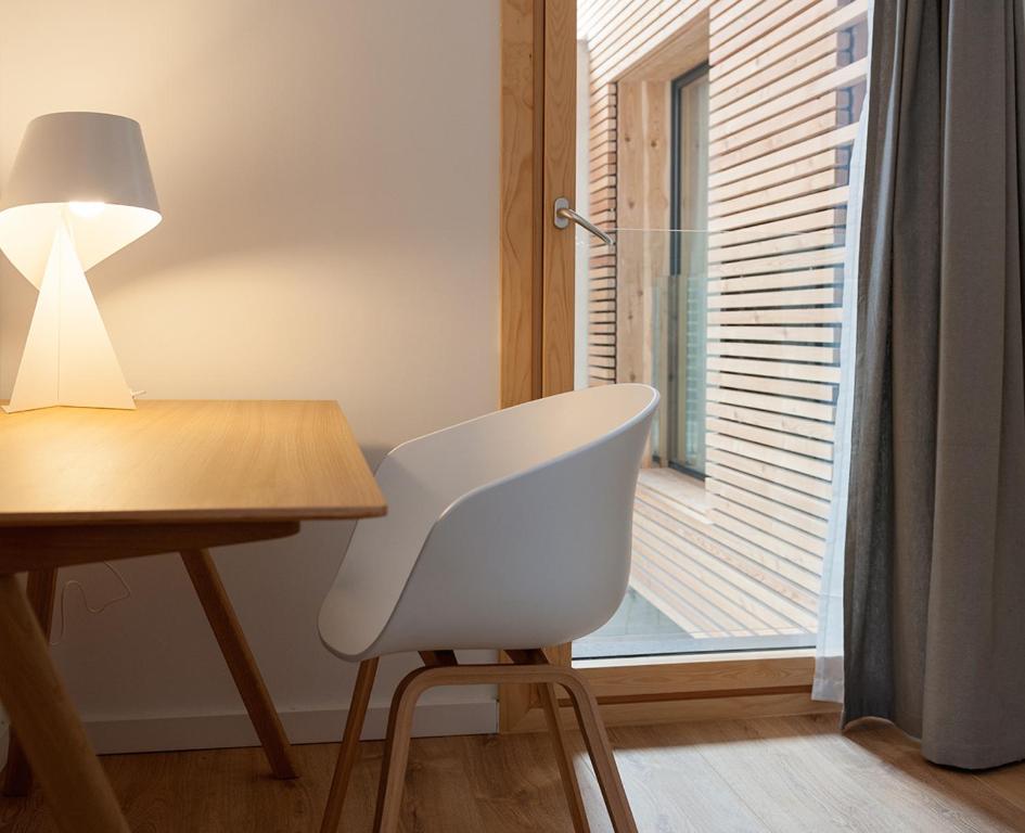 a white chair sitting next to a desk with a window at Casa Del Castell in Móra d'Ebre