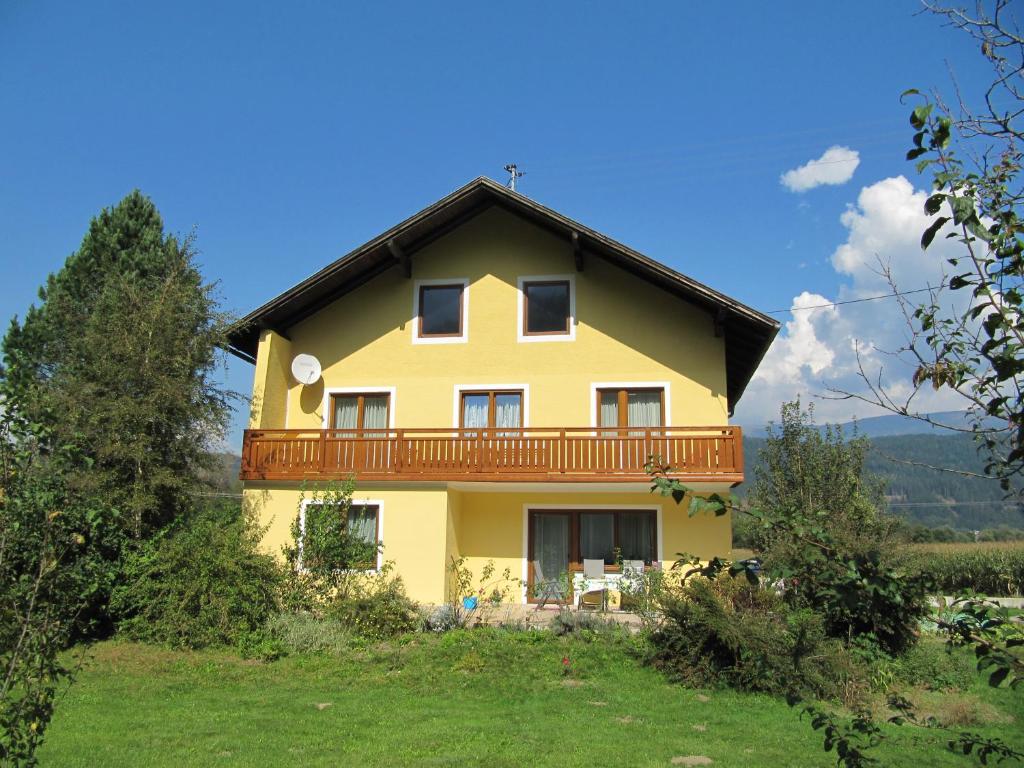 Una casa amarilla con balcón en la parte superior. en Haus Mup en Spittal an der Drau