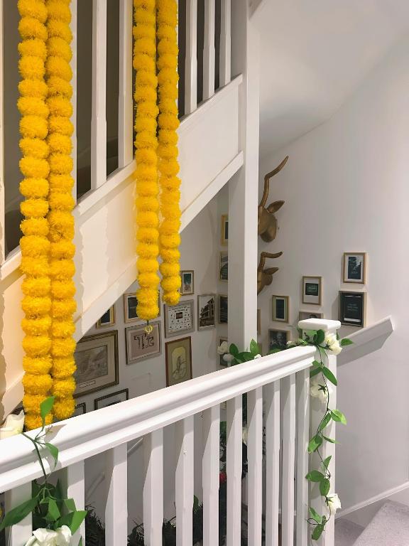 a staircase with yellow garlands on the wall at Redheema in Lower Sydenham Station