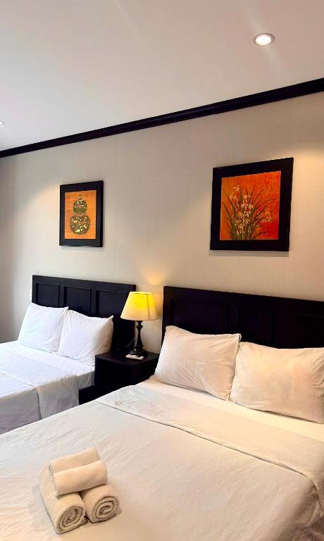 a hotel room with two beds with towels on them at HY Local Budget Hotel - 5 mins walk to Hoi An Ancient Town in Hoi An