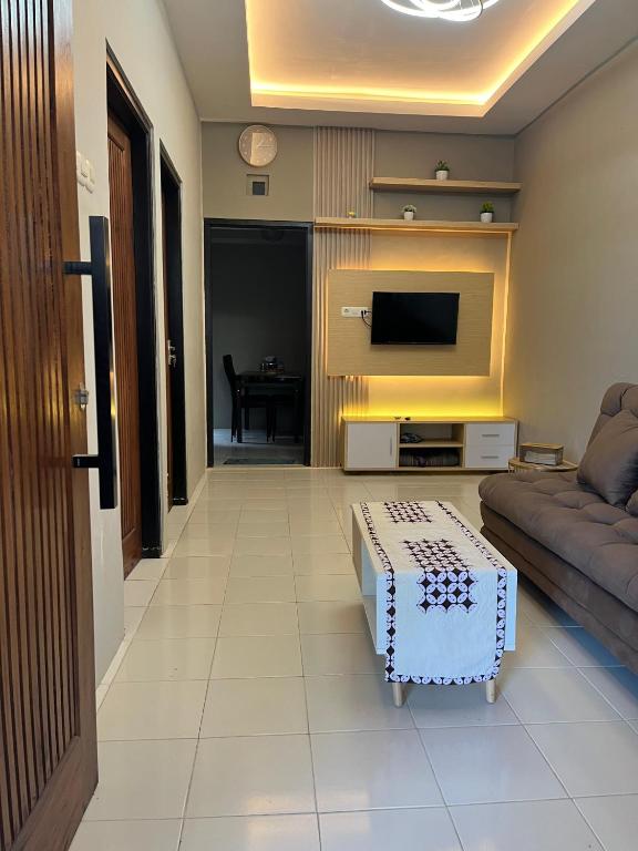 a living room with a couch and a tv at ABD Home Blitar syariah at Blitar City in Blitar