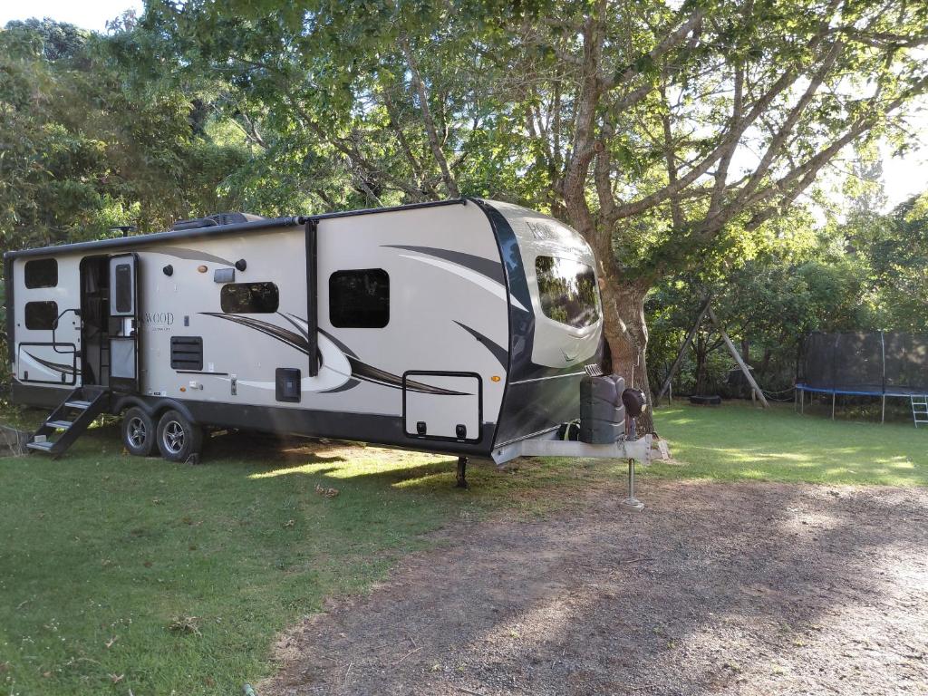 Tapu蒂玛塔小屋旅馆的停在树旁的白色拖车