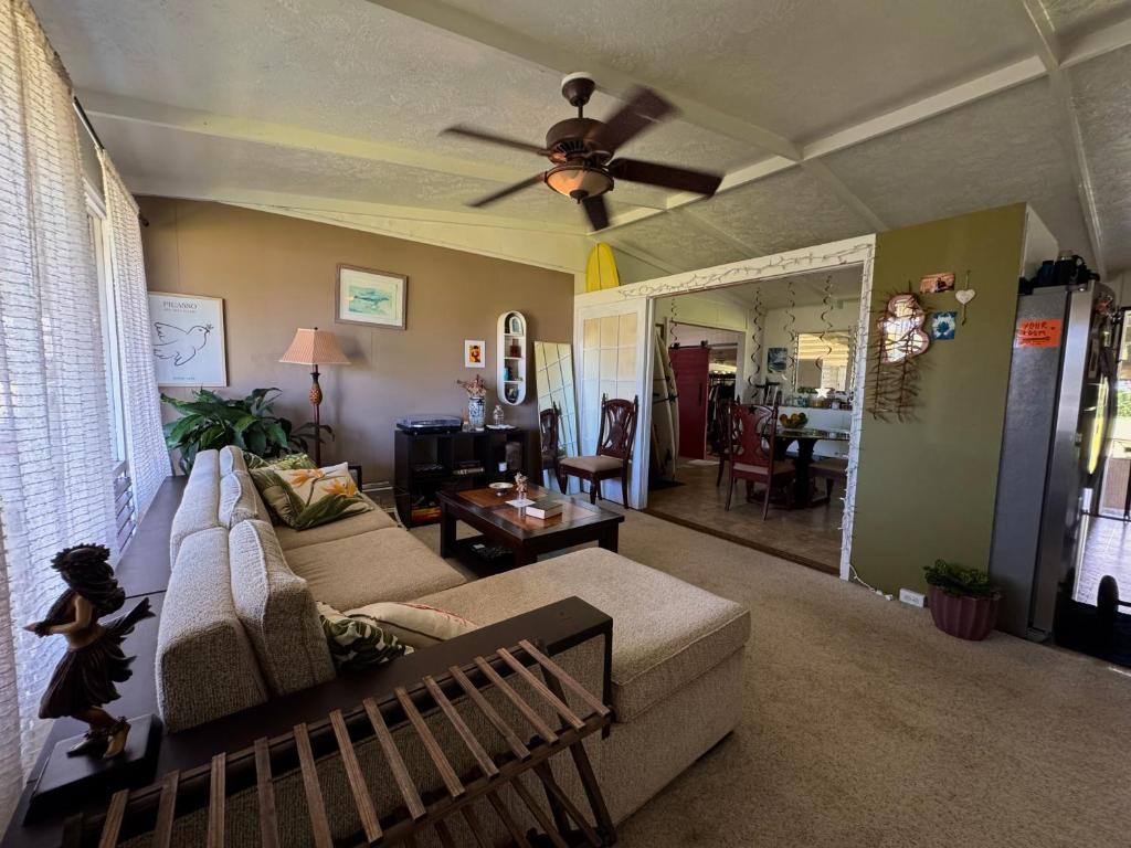 uma sala de estar com um sofá e um ventilador de teto em Master Suite with Private Bath 15 min drive to beach em Hilo