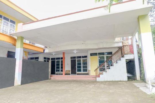 a house with a staircase in front of it at FIVE HOTEL Sarangan in Sarangan