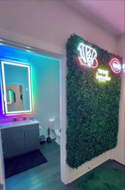 a bathroom with a green wall with a mirror at The 513 Flat! 1BR, 1Bath Apt with Pool and Riverfront View! Free Gated Parking! Only Steps from The banks & Stadiums! in Cincinnati