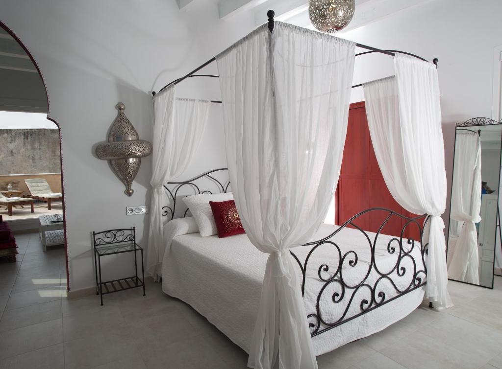 Schlafzimmer mit Himmelbett und weißen Vorhängen in der Unterkunft Puerta la Mar in Tarifa