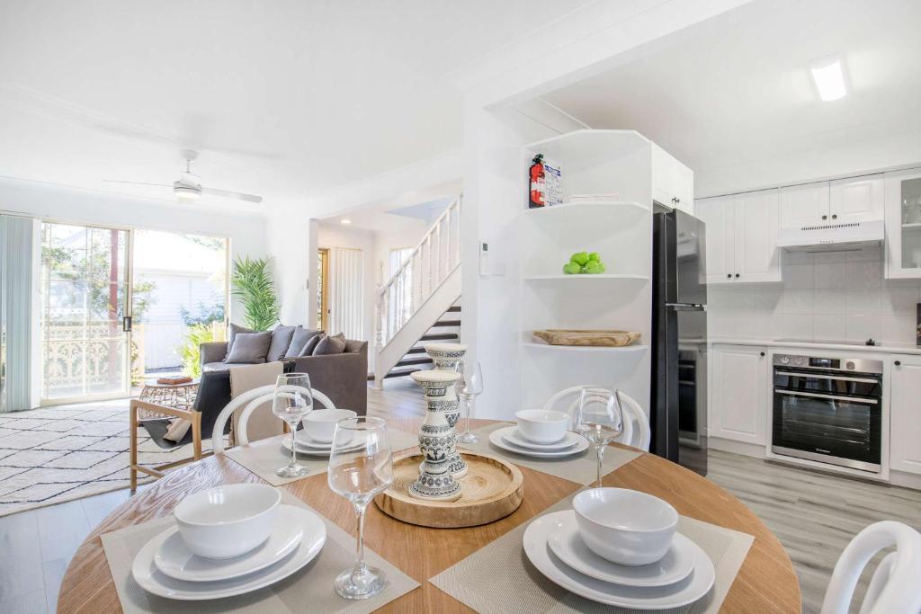 a kitchen and living room with a table and chairs at Aquamarine - modern & bright Huskisson townhouse in Huskisson