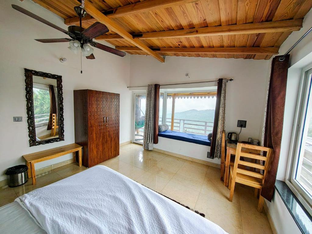 a bedroom with a bed and a large window at Abhi's Cottage in Mukteshwar