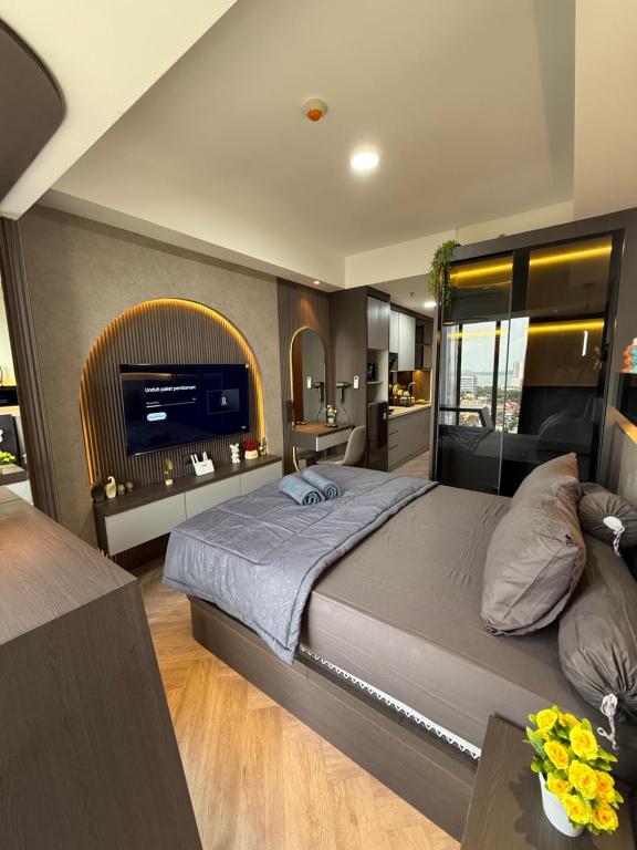 ein Schlafzimmer mit einem großen Bett und einem Fernseher in der Unterkunft Modern Luxury Studio at Pollux by Superstay in Batam Center