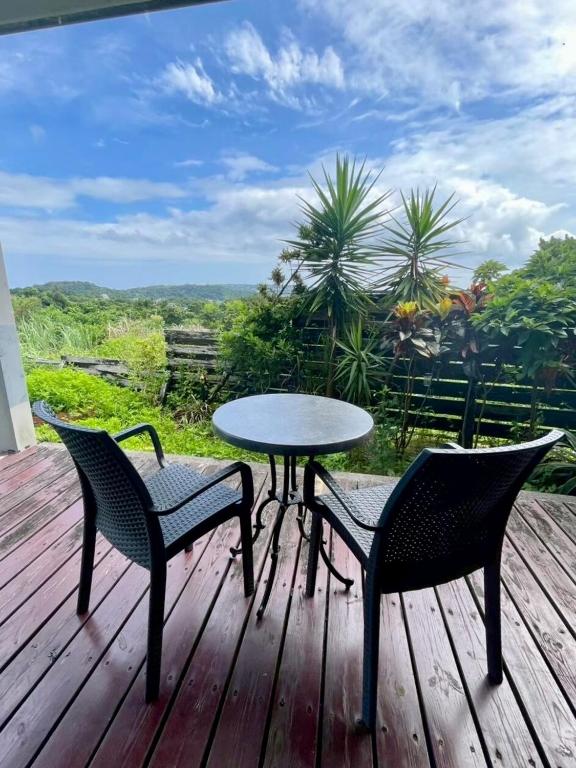 a table and chairs on a wooden deck with a table and chairs at Container Suite 75 in Nago