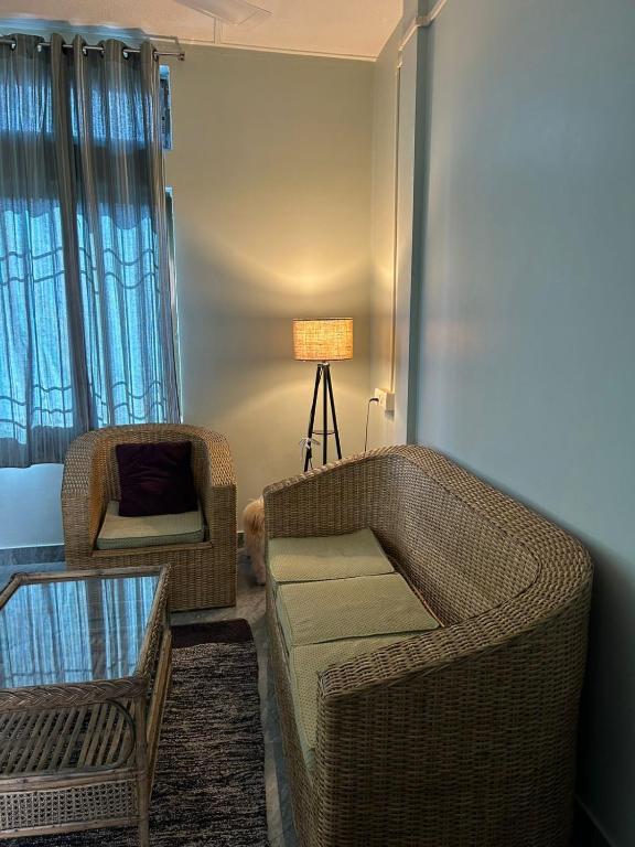 a living room with a couch and a chair at BeeHive Homestay in Hāflong