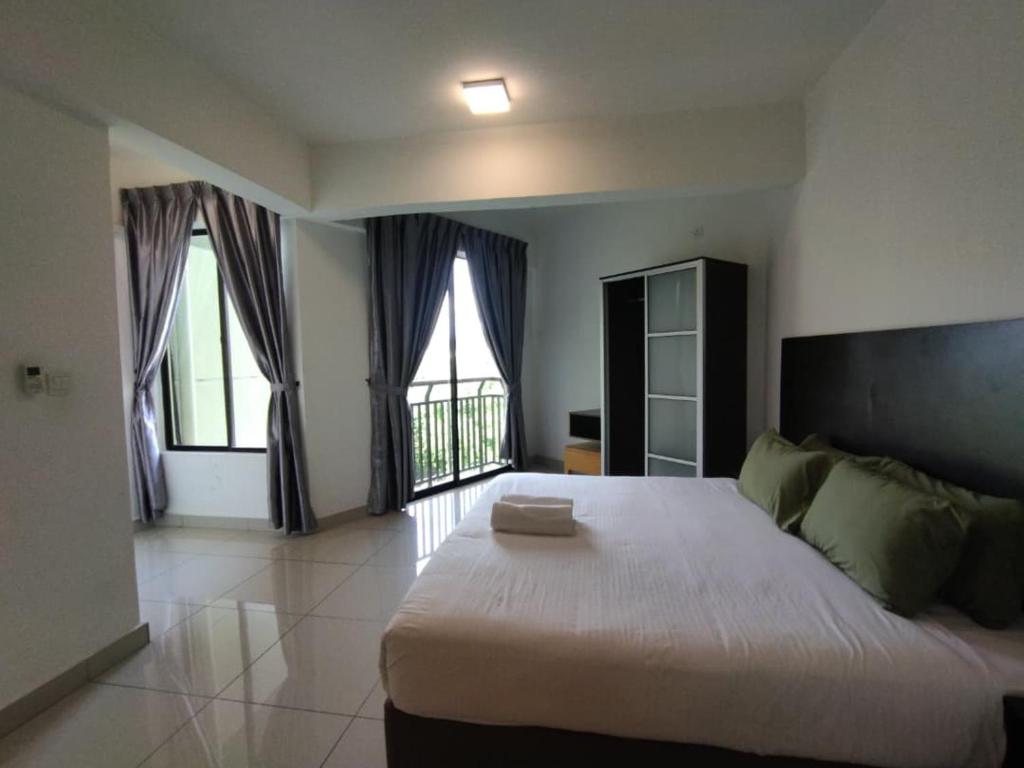 een slaapkamer met een groot bed en twee ramen bij Marina sunset view in Lumut