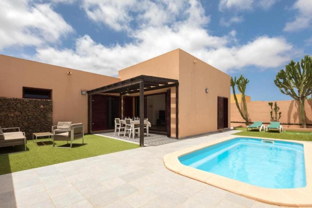 a villa with a swimming pool and a house at Tajora House by Best Holidays Fuerteventura in La Oliva