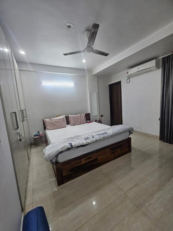 a bedroom with a bed with a ceiling fan at Independent Floor in Gurgaon