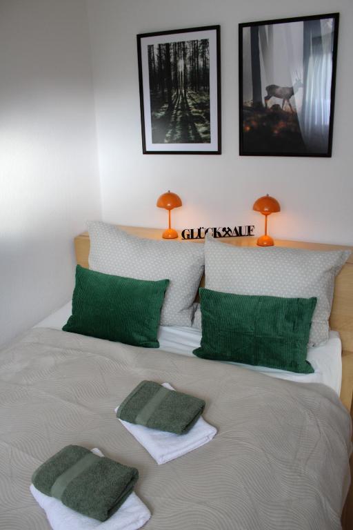 a bed with green and white pillows on it at GlückAufBud Schwarzenberg WLAN Netflix Stellplatz in Schwarzenberg/Erzgebirge