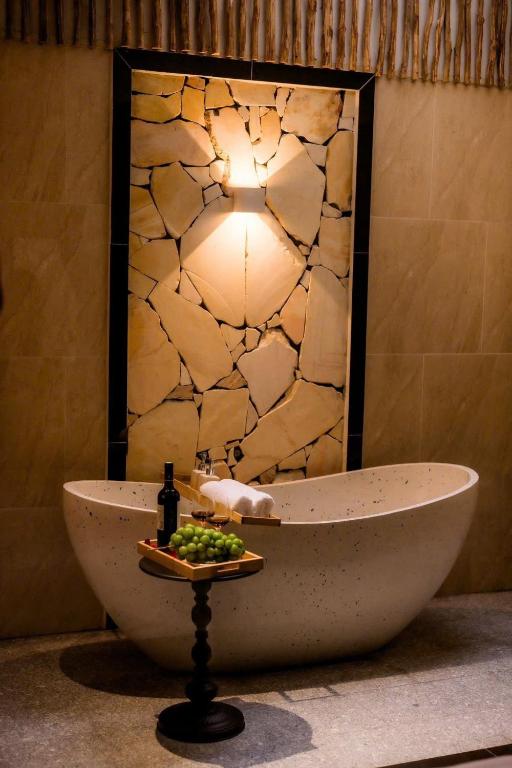 a bathroom with a bath tub and a light at Vân Trang Hotel in Vĩnh Long