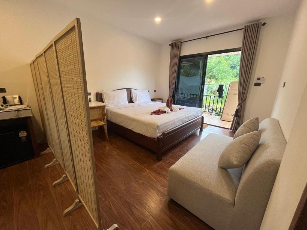 een slaapkamer met een bed, een bank en een raam bij Serenia Garden Resort in Ko Lanta Yai