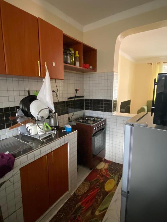 a kitchen with a sink and a refrigerator at Pazurihome in Embu