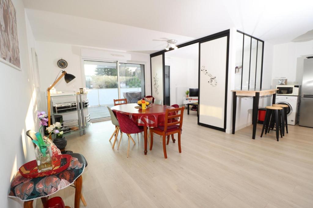 ein Wohnzimmer mit Tisch und Stühlen und eine Küche in der Unterkunft L'Aigue Marine by TAH - Top emplacement & Parking in Pornichet