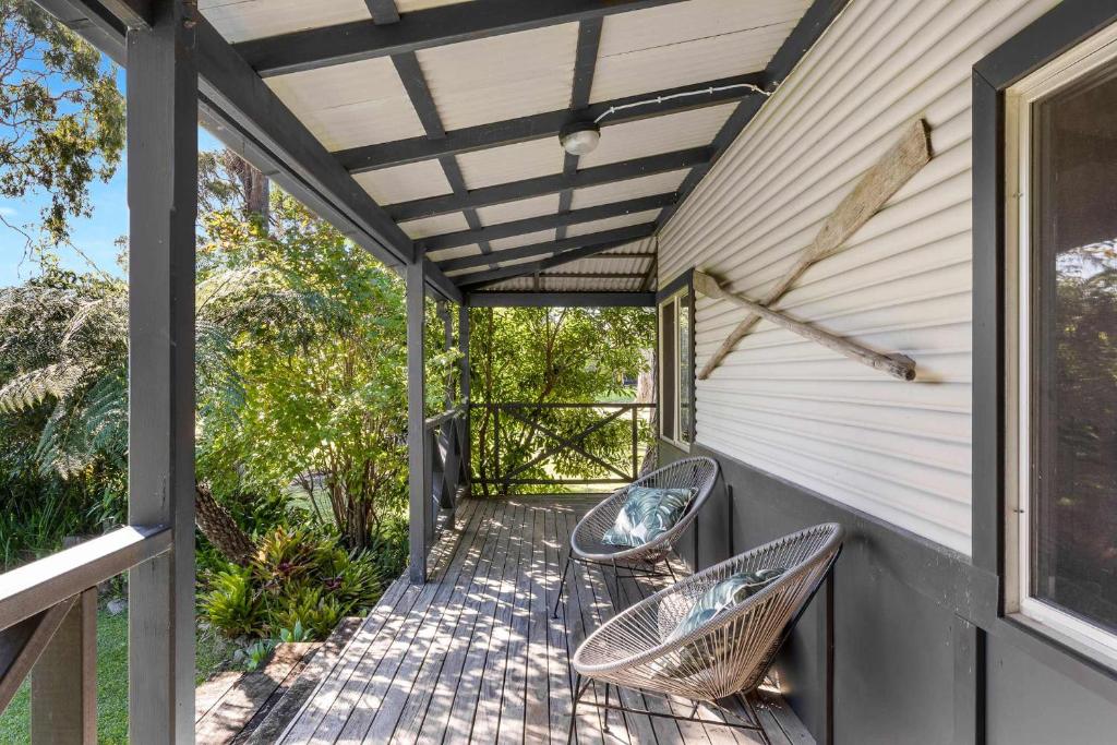 een veranda met 2 stoelen en een luifel bij Ma Te Kokorou - pet-friendly Huskisson pool escape in Huskisson
