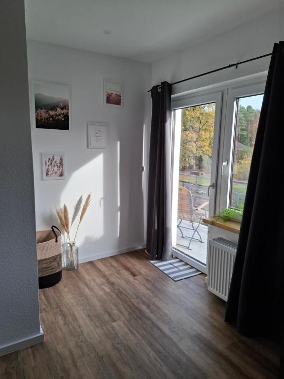 un salon vide avec une porte coulissante en verre dans l'établissement Servus & Moin - Bei uns Daheim!, à Meißendorf