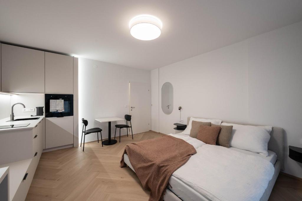 a white bedroom with a bed and a kitchen at Studio 4 in Bad Schallerbach