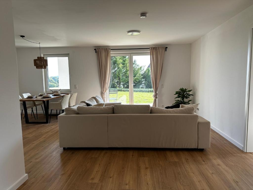 ein weißes Wohnzimmer mit einer Couch und einem Tisch in der Unterkunft Ferienwohnung an der Windmühle in Horn-Bad Meinberg
