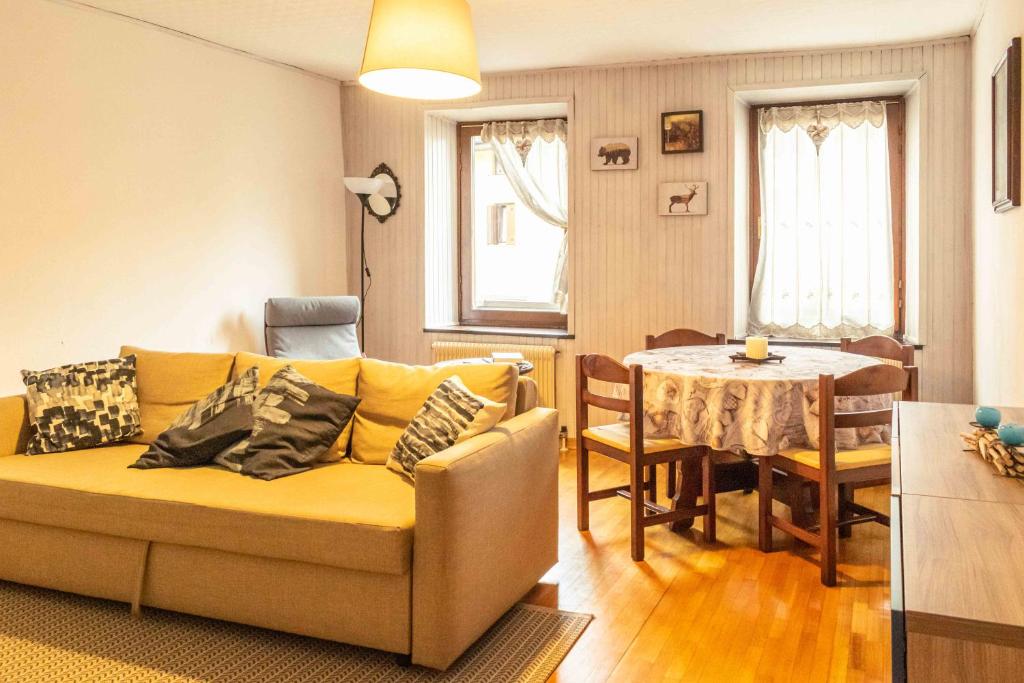 un soggiorno con un divano e un tavolo di Casa tipica nelle Dolomiti Trentine a Mezzano