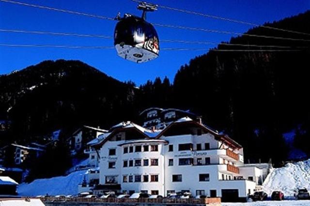 einem Skilift in der Luft vor einem Gebäude in der Unterkunft Hotel Persura in Ischgl