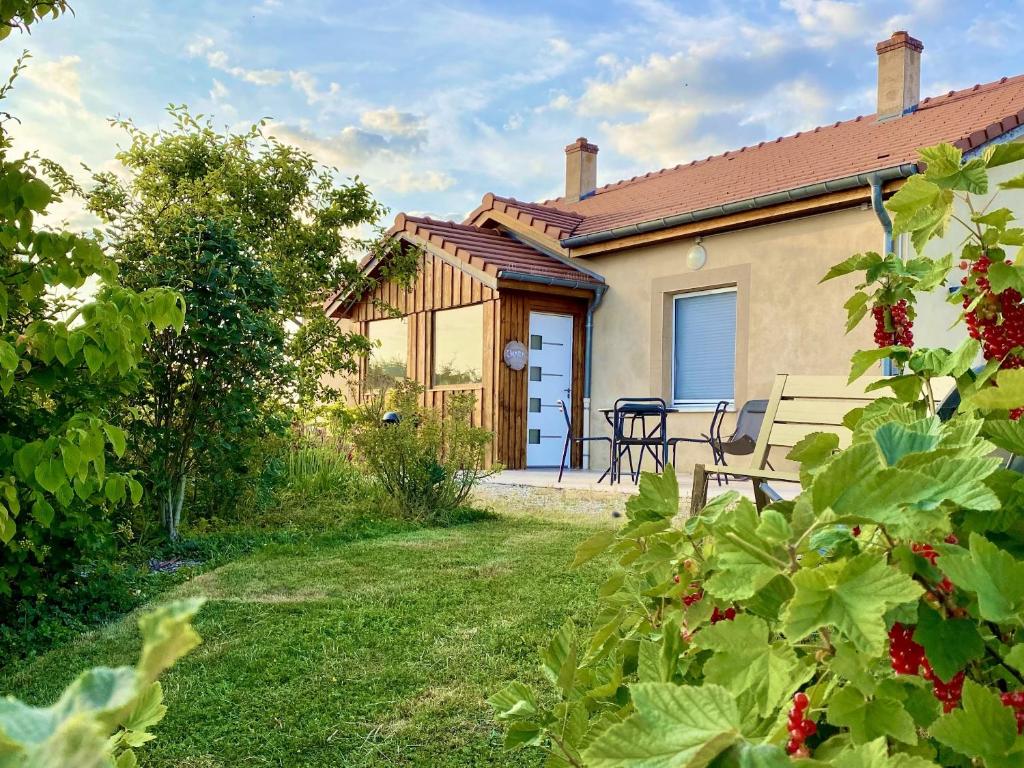 ein Haus mit einem Garten und einer Bank im Hof in der Unterkunft La Villa Mellifera in Cernay-lès-Reims