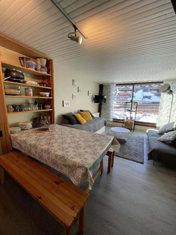 a living room with a table and a couch at Studio Buron des Gardes in Le Lioran