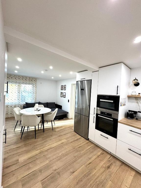 eine Küche und ein Esszimmer mit einem Tisch und einem Kühlschrank in der Unterkunft Ferienwohnung in Hanau am Main